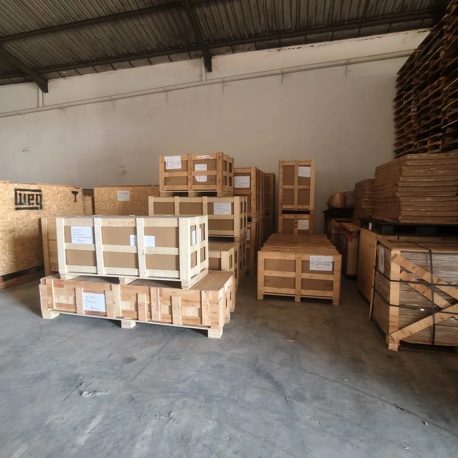 Peti kayu dan barang berkemasan di gudang — dokumentasi Chindo Cargo